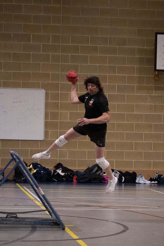 Tchoukball player shooting at a rebound frame